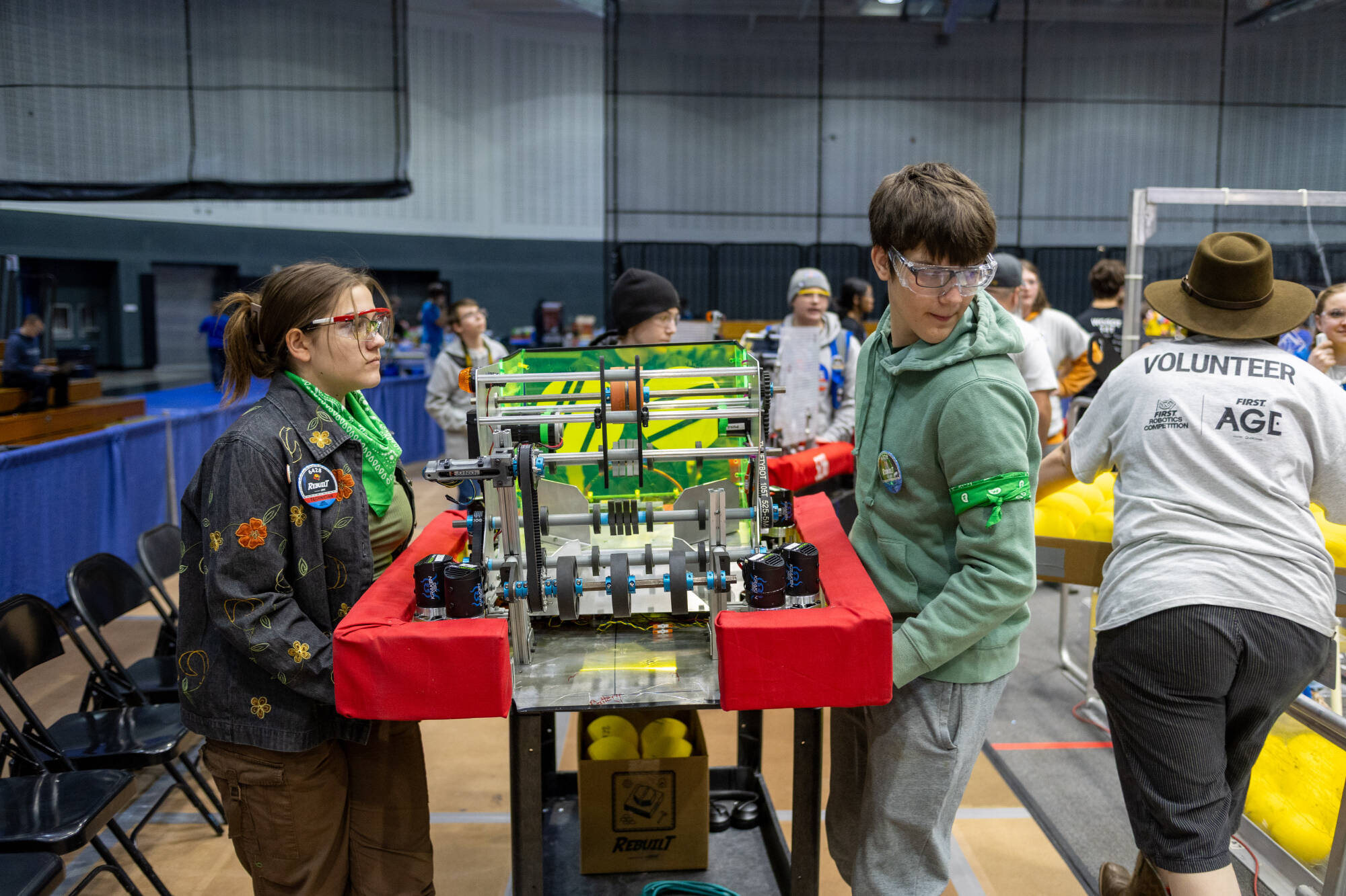 Two high school students carry their robot at the 2026 FIM District West Michigan Event in the GVSU Fieldhouse
